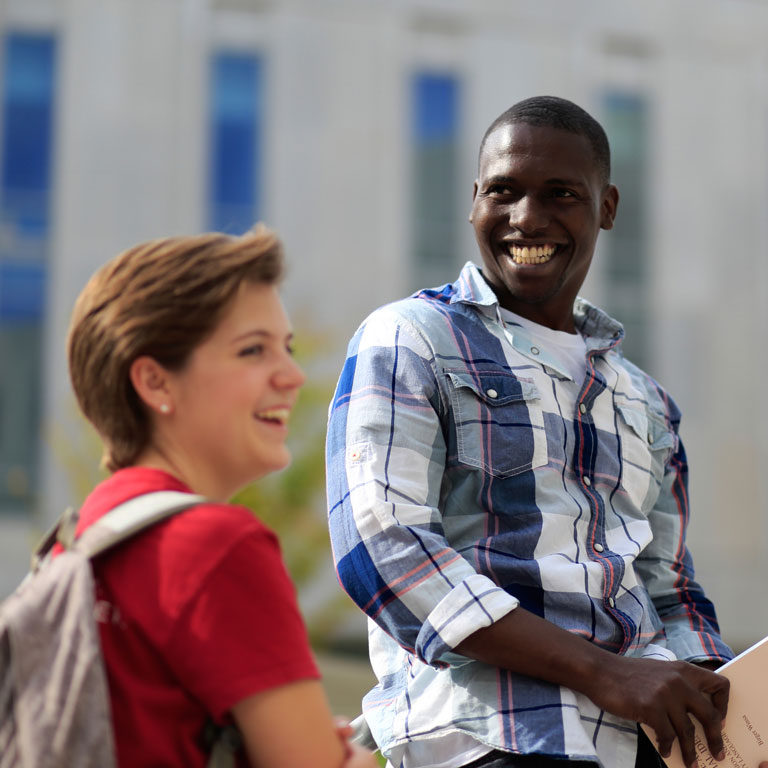 Male and female student smiling, laughing